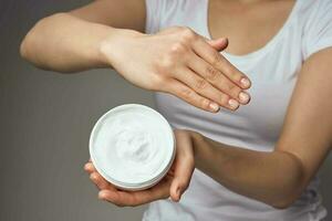 donna con crema nel mani cosmetici mano pelle cura avvicinamento foto