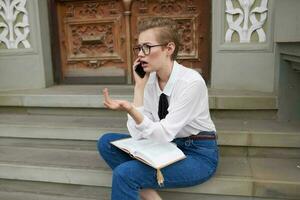 bella donna con bicchieri a piedi in giro il città con un' libro formazione scolastica foto