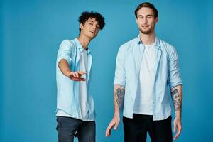 Due amici nel un sbottonato camicia e nel bianca magliette su un' blu sfondo Esprimere a gesti con mani ritagliata Visualizza festa foto