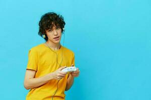 uomo giallo maglietta con telecomando da gioco video Giochi blu sfondo foto
