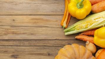 verdure arancioni e gialle sulla tavola di legno foto