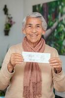 anziano donna a sua casa Tenere sua vaccinazione certificato dopo ottenere il covid-19 vaccino a un' vaccinazione nel Colombia. autentico vaccinazione certificato. vero paziente foto