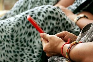 mano di indiano donna utilizzando mobile Telefono foto