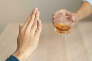 alcolismo, triste depresso asiatico giovane uomo rifiutare, spingere alcolizzato bevanda bicchiere, bevanda whisky, seduta solo a notte. trattamento di alcool dipendenza, avendo soffrire abuso problema alcolismo concetto. foto