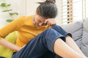 flatulenza asiatico giovane donna, ragazza mano nel stomaco dolore, soffrire a partire dal cibo avvelenamento, addominale dolore e colon problema, gastrite o diarrea. paziente gonfiarsi, addome o infiammazione, concetto. foto