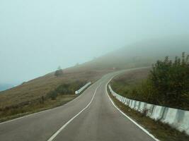 nebbioso vuoto autostrada su attraverso il passaggio. strada attraverso un' denso fo foto