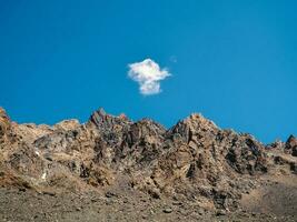 piccolo bianca nube al di sopra di un' roccioso montagna gamma. montagna naturale minimalista sfondo. foto