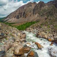 energia montagna fiume flussi giù a partire dal il ghiacciaio. bellissimo alpino paesaggio con azzurro acqua nel un' veloce fiume. il energia di il maestoso natura di il altopiani. foto