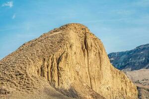 grande sabbia montagna. bellissimo deserto paesaggio, tra il sabbie e pietre Là è un' grande montagna contro il sfondo di un' blu cielo. foto