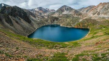 blu glaciale lago alto nel il montagne. atmosferico verde paesaggio con un' lago nel un' alta altitudine valle. altai montagne. foto