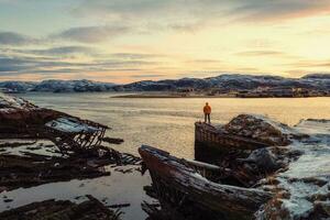 cimitero di navi, inverno tramonto Visualizza nel un vecchio pesca villaggio su il riva di il barents mare, il Kola penisola, teriberka foto