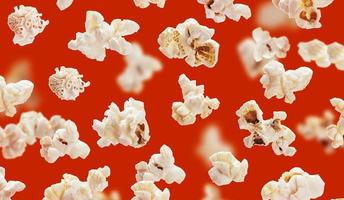 deliziosi chicchi di popcorn closeup su sfondo rosso foto