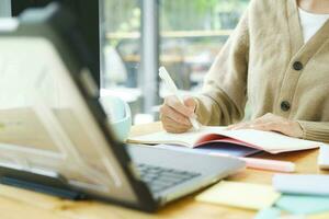 giovane femmina Università alunno usi un' computer per accesso il Internet per in linea apprendimento. foto