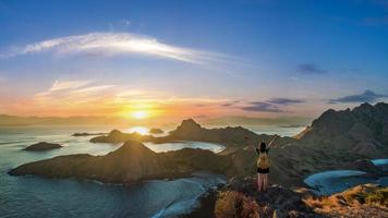 una donna in piedi sulla cima dell'isola di Padar nel momento del tramonto