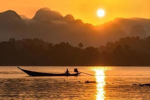 immagine della sagoma di una barca a vela in una diga nel sud della Thailandia al mattino.