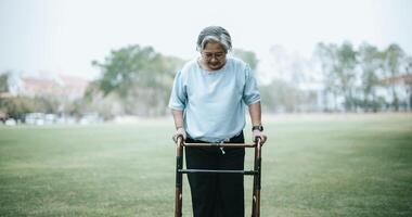 maturo asiatico donna usi un' supporto dispositivo mentre formazione per camminare foto