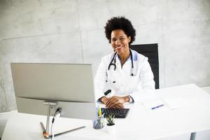 medico sorridente e lavorando su un computer foto