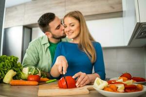 un' giovane coppia cucinando insieme foto