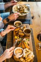 vicino su di adulto coppia chi è avendo cena e vino a ristorante. foto