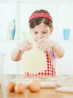 un' giovane ragazza cucinando foto