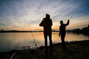 padre e figlio siamo pesca su soleggiato inverno giorno foto