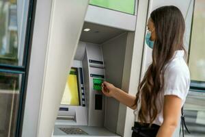 un' donna utilizzando un ATM foto