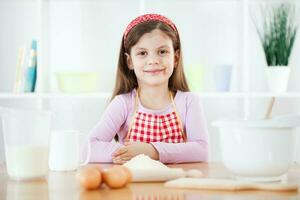 un' giovane ragazza cucinando foto