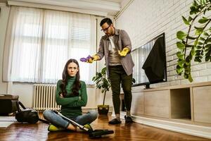giovane coppia è pulizia loro appartamento foto