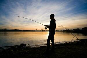 un' ragazzo è pesca su un' soleggiato giorno foto