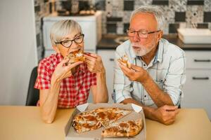 un' anziano coppia mangiare Pizza foto