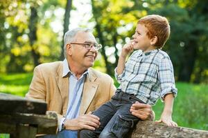 un' nonno e il suo nipote giocando scacchi foto