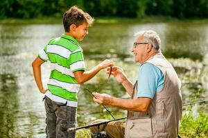 un' nonno e il suo nipote pesca foto