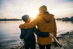 padre e figlio siamo pesca su soleggiato inverno giorno foto