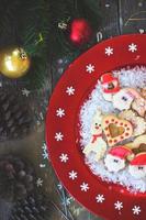 biscotti di Natale sulla zolla festiva rossa con i fiocchi di neve foto