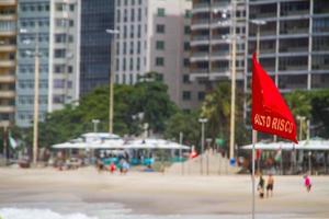 bandiera rossa scritta in portoghese, ad alto rischio sulla spiaggia di copacabana a rio de janeiro