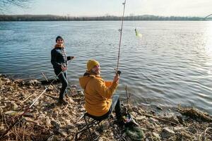 padre e figlio siamo pesca su soleggiato inverno giorno foto