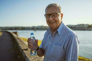 anziano uomo potabile acqua all'aperto foto