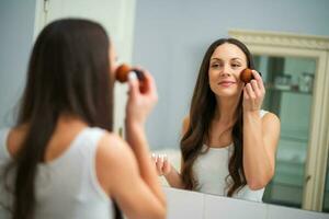 un' donna chi mette su trucco foto