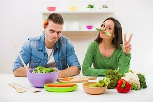 un' coppia avendo divertimento fabbricazione un' insalata foto