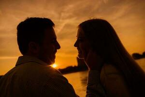 un' giovane coppia al di sopra di il tramonto foto