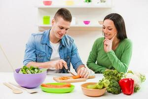 un' coppia avendo divertimento fabbricazione un' insalata foto