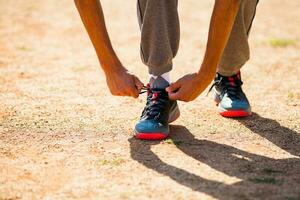 un' uomo legatura il suo lacci delle scarpe foto