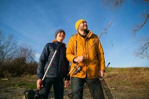 padre e figlio siamo pesca su soleggiato inverno giorno foto