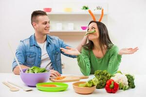 un' coppia avendo divertimento fabbricazione un' insalata foto