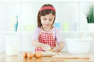 un' giovane ragazza cucinando foto