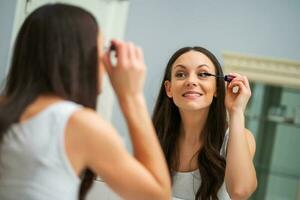 un' donna chi mette su trucco foto