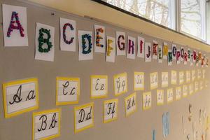 blocchi di lettere colorate e corsivo sul muro di una scuola elementare foto