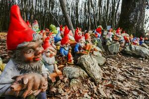 colorato giardino gnomi a un' posto nel il foresta durante escursioni a piedi foto