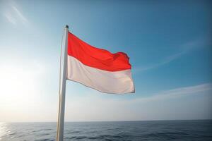 Indonesia nazionale bandiera agitando nel il blu cielo su il oceano sfondo. rosso e bianca bandiera con nuvole. ai generato foto