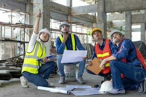 squadra di ingegnere, architetto, contraente e caposquadra incontro a il costruzione edificio luogo con pavimento Piano per vero tenuta sviluppo progetto industria e alloggiamento ispezione sequenza temporale uso foto